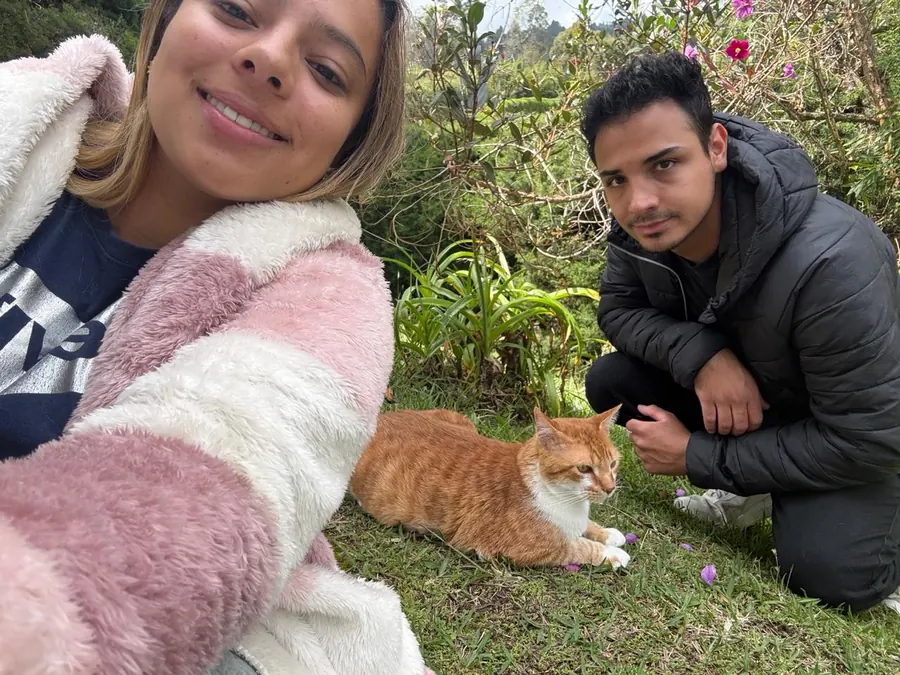 Sparky en el jardín, con la pareja agachada a su lado